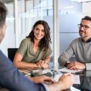 Smiling mature couple meeting with bank manager for investment